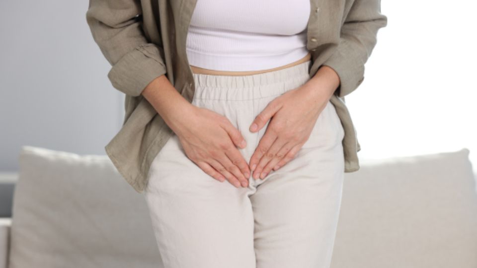 Mujer con dolor pélvico e incontinencia urinaria sosteniendo su zona pélvica